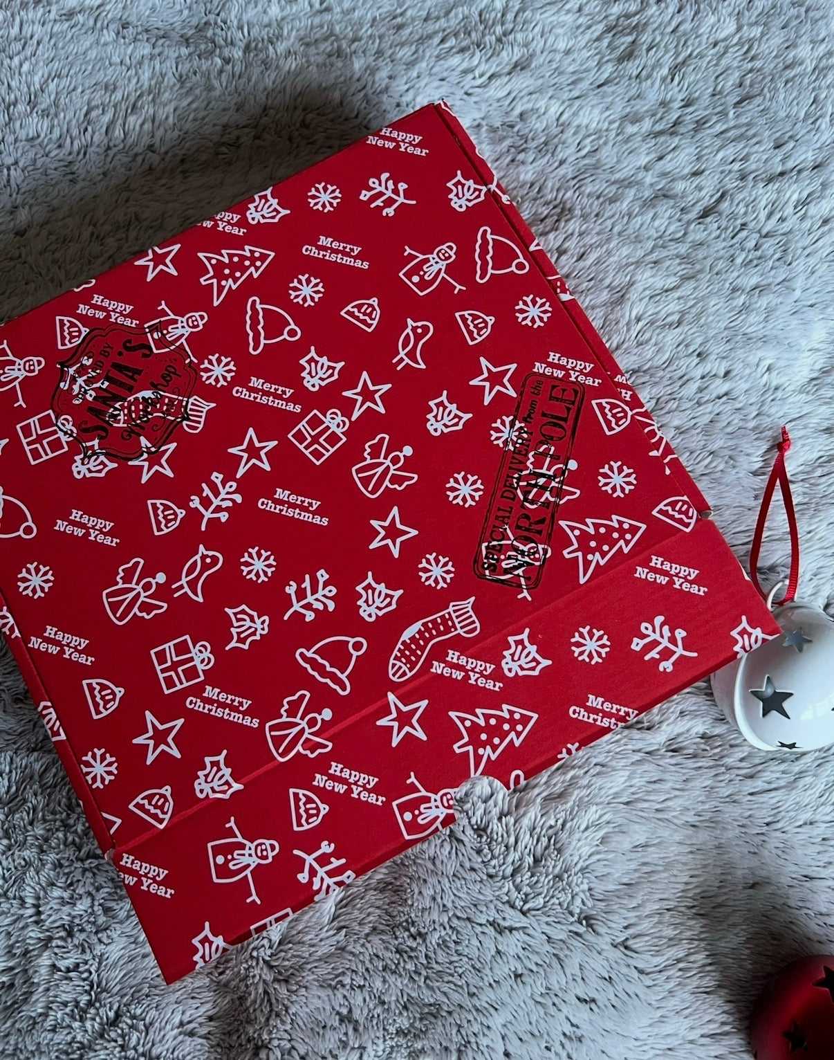 Red patterned fabric with white text and designs on a gray surface