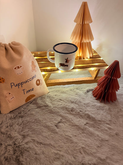 Cup with a dog design on a fluffy surface next to a decorative mirror.