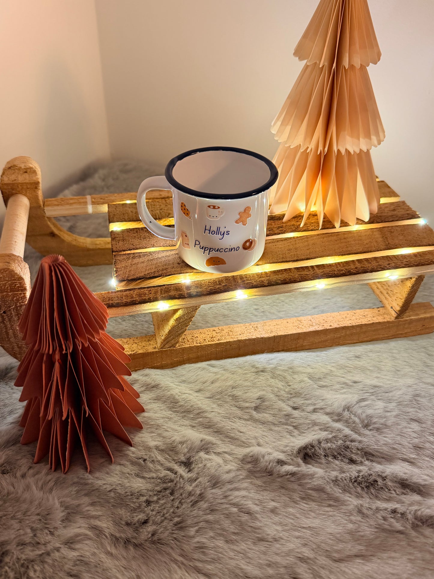 Mug with decorative elements on a wooden stand against a textured wall.