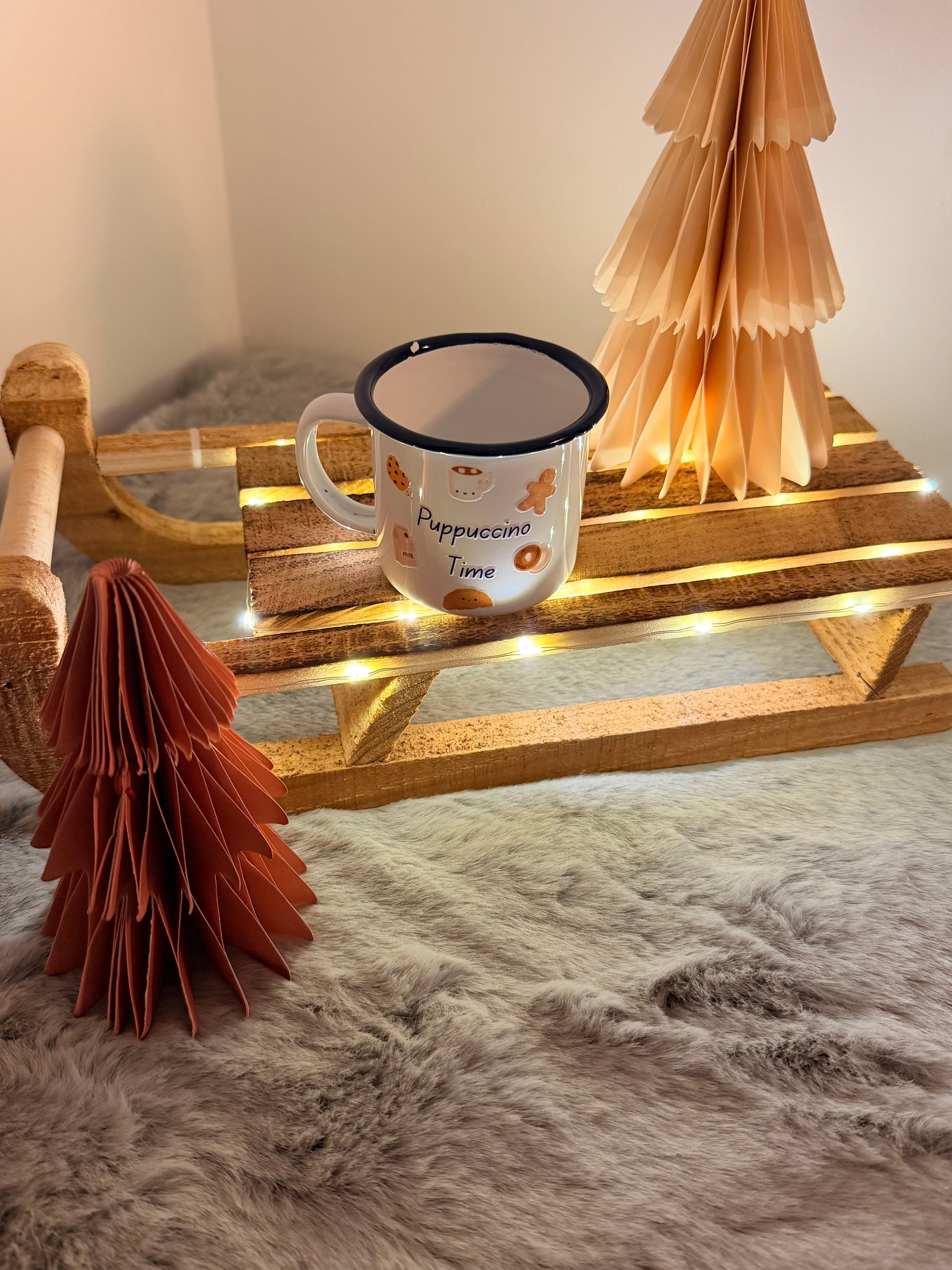 Mug with decorative elements on a wooden stand against a textured wall.