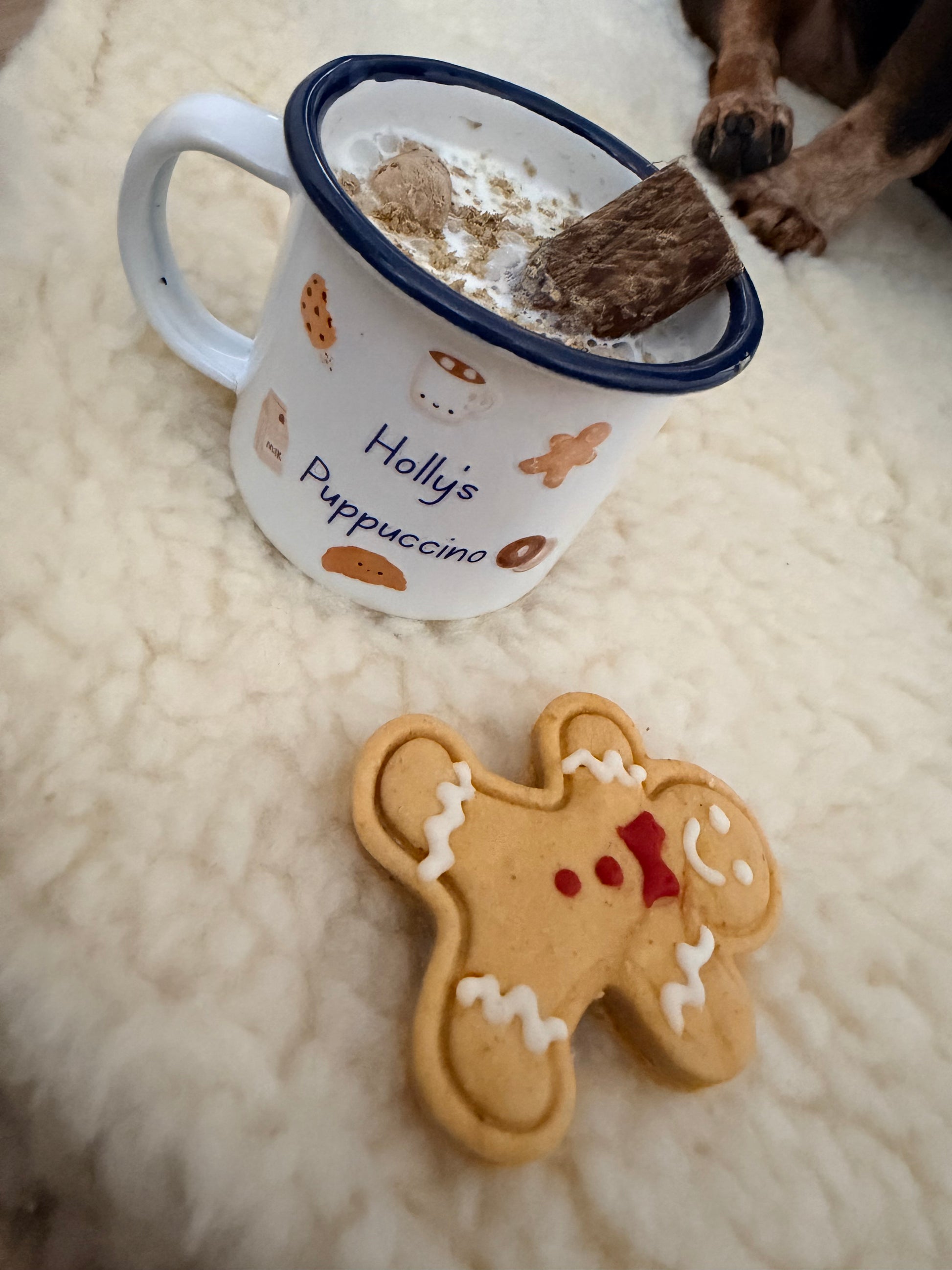 Gingerbread man cookie and mug with paw print on a soft surface