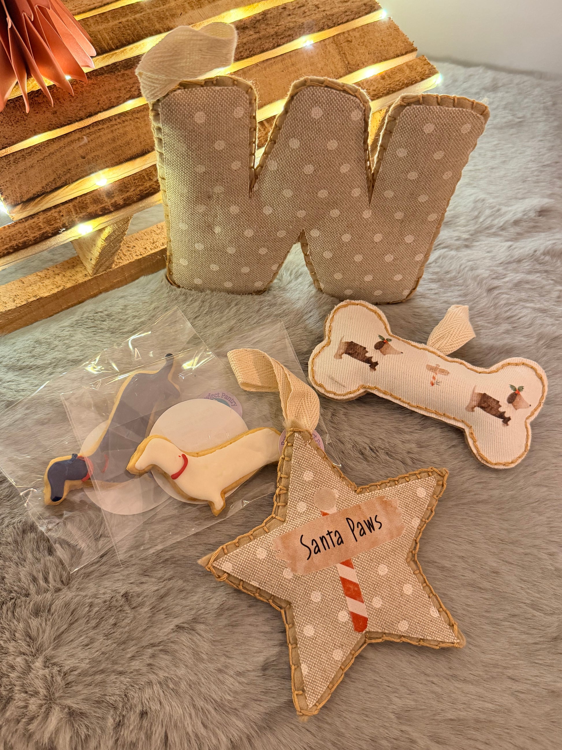 Dog decorations including a bone, star, and paw-shaped toy on a textured surface.