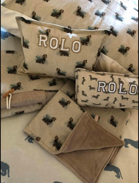 two cushions, a blanket and crate cover in linen cotton with dachshund print reading ROLO