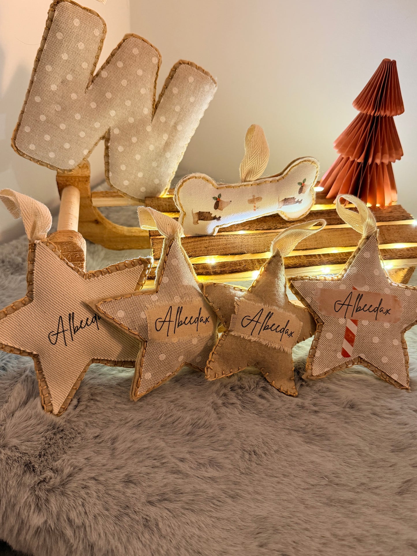 Decorative star-shaped ornaments with 'Albeedax' text on a soft surface.