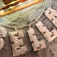 Decorative letter banner spelling 'bella' on a textured surface with lights in the background.