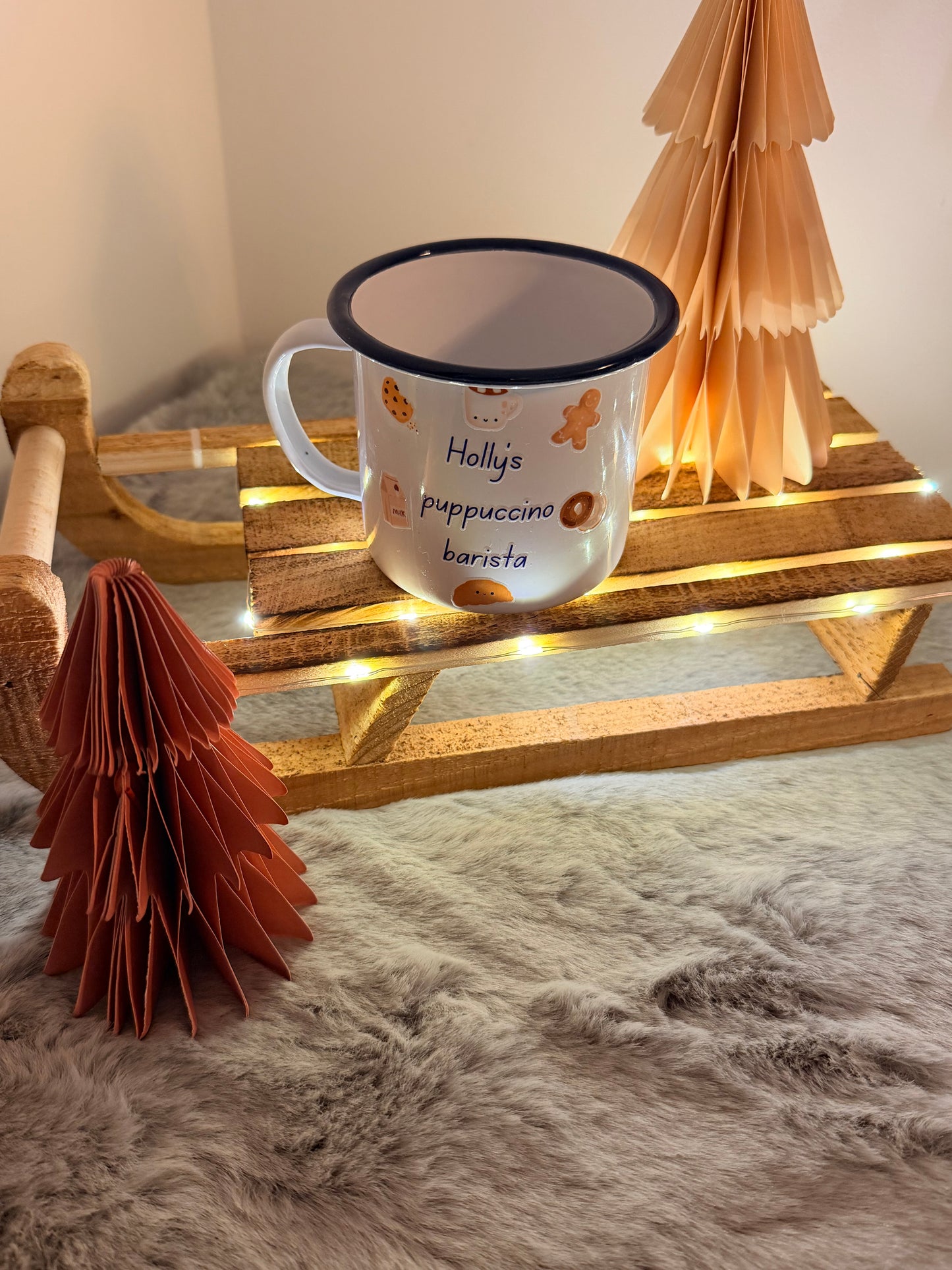 Mug with decorative elements on a wooden stand against a textured wall.