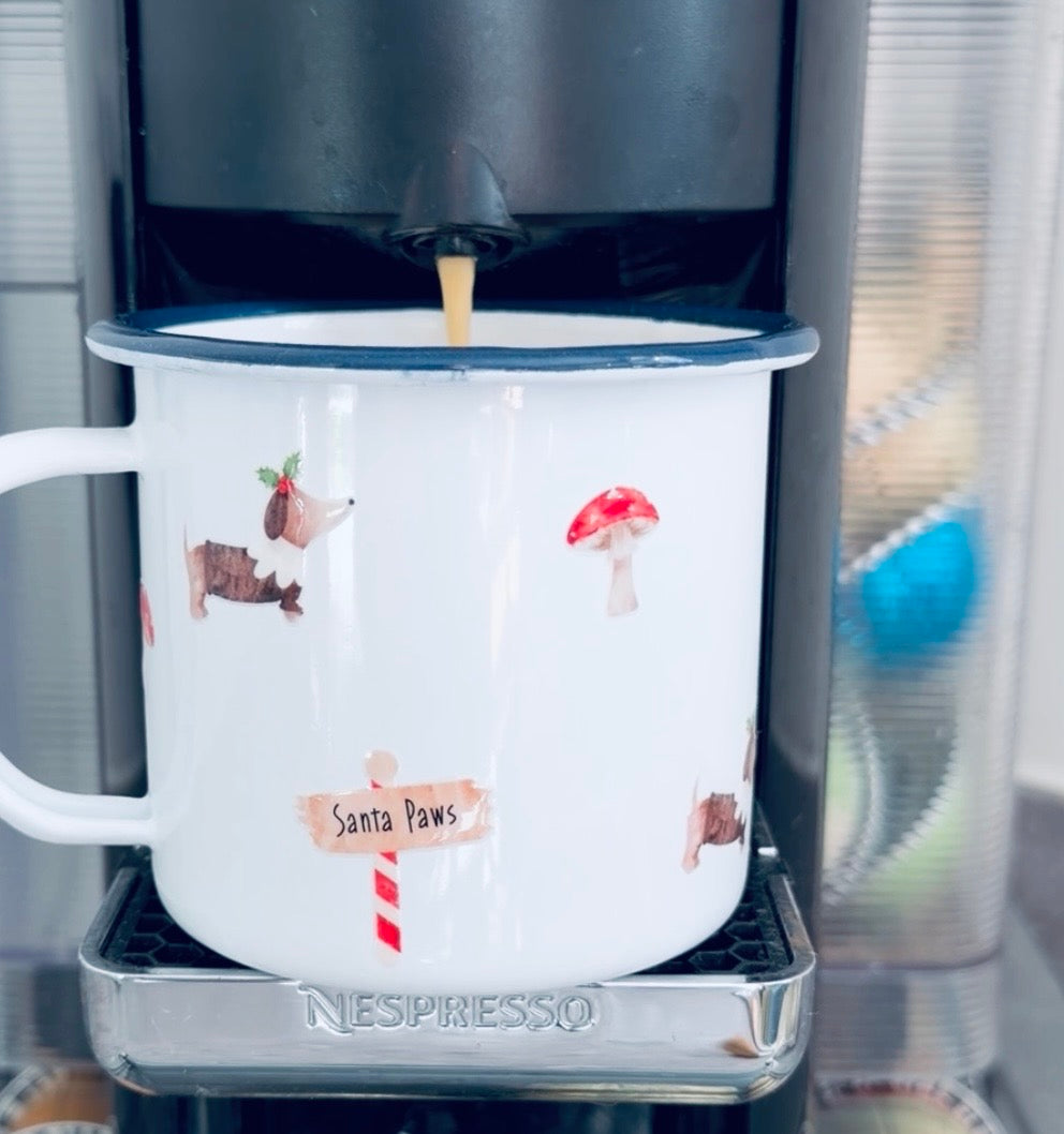 Nespresso machine dispensing coffee into a mug with cartoon designs.