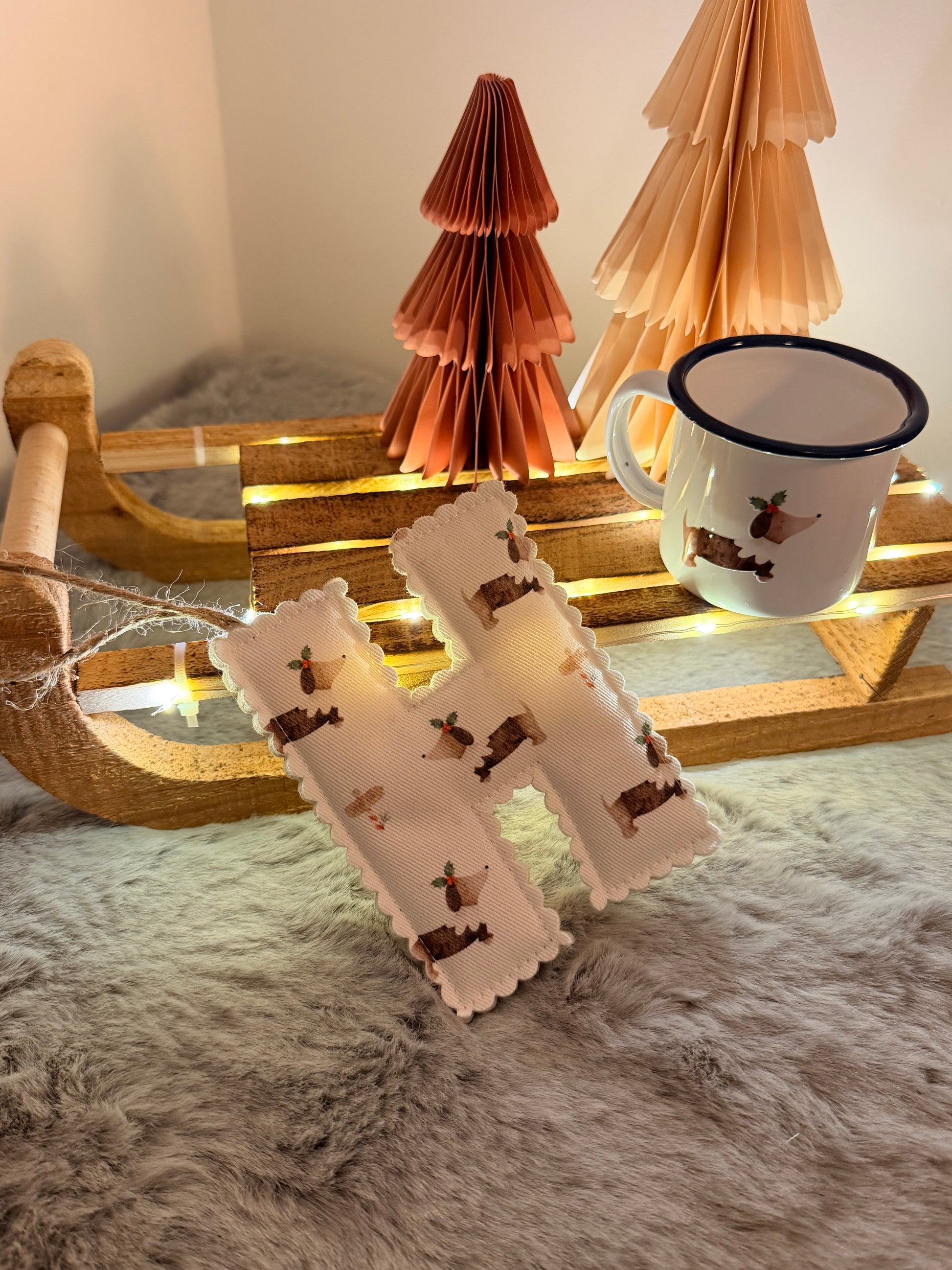 Decorative lamp with wooden base, white shade with dog pattern, and mug on top.